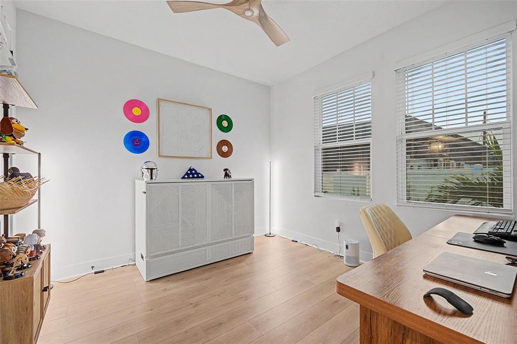 A home office features a white cabinet, a wooden desk, and light wood-look flooring — 6605 N NEBRASKA AVENUE UNIT 28, TAMPA, FL