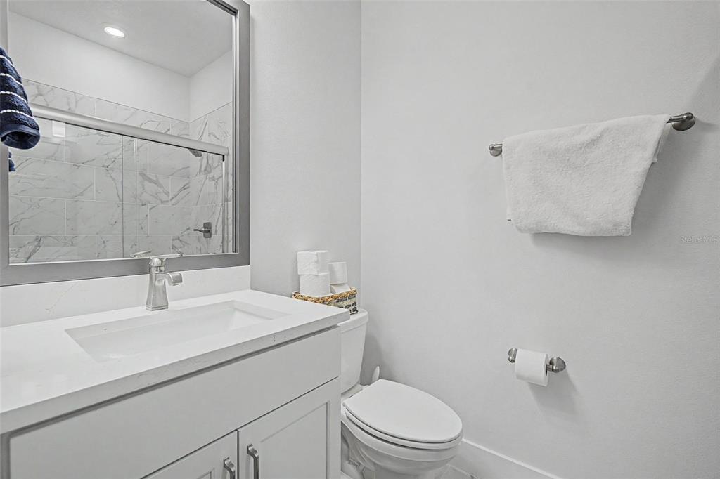 A bathroom features a white vanity with a sink, a toilet, and a glass-enclosed shower — 6605 N NEBRASKA AVENUE UNIT 28, TAMPA, FL