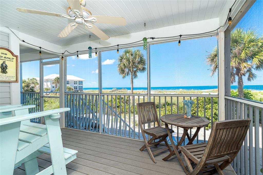 A screened-in porch with a ceiling fan, wooden furniture, and a view of the ocean — 7500 PALM ISLAND DRIVE S UNIT 2111, PLACIDA, FL