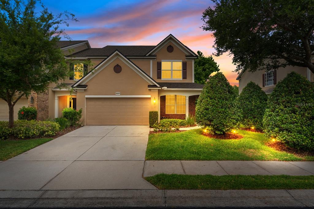 A two-story suburban house with a tan stucco exterior, a two-car garage, and landscaped lawn — 4635 POND RIDGE DRIVE, RIVERVIEW, FL