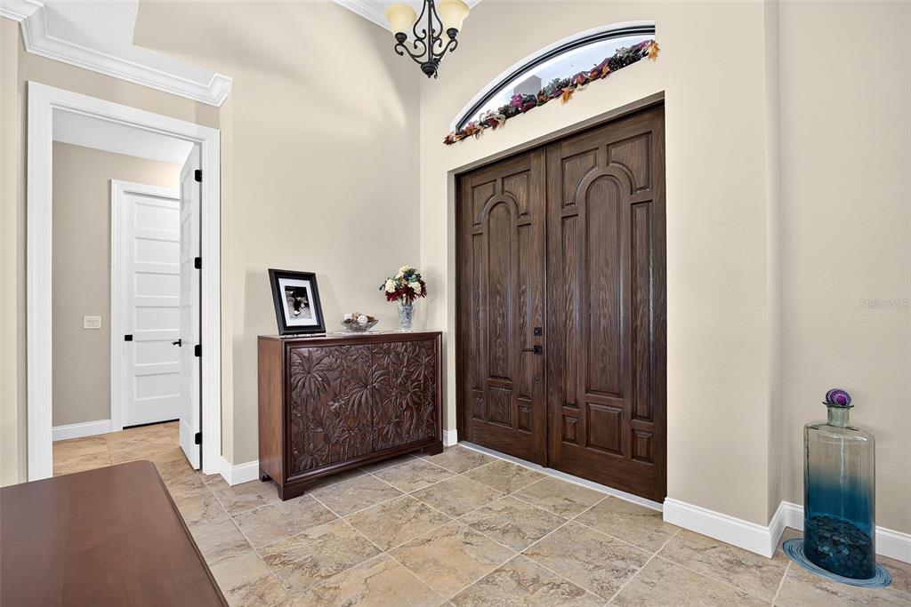 A foyer with tile flooring, a wooden cabinet, and double front doors with an arched transom — 3478 WENONA DRIVE, NORTH PORT, FL