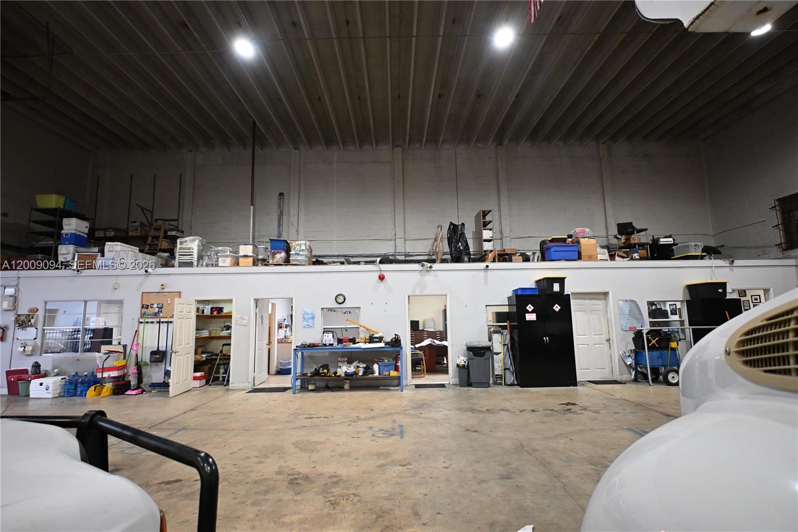 A large warehouse space features a concrete floor, high ceilings, and a storage loft area — 4450 E 10th Ct, Hialeah FL 33013, HIALEAH, FL