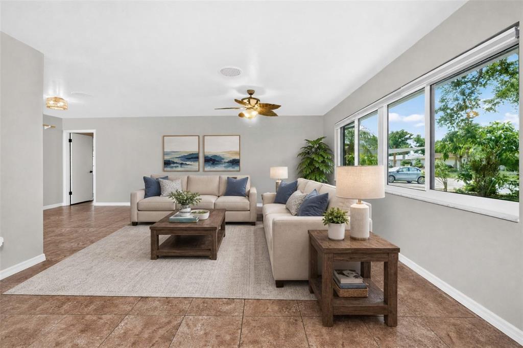 A living room features two beige sofas, a wooden coffee table, and large windows — 559 MOUNT VERNON DRIVE, VENICE, FL