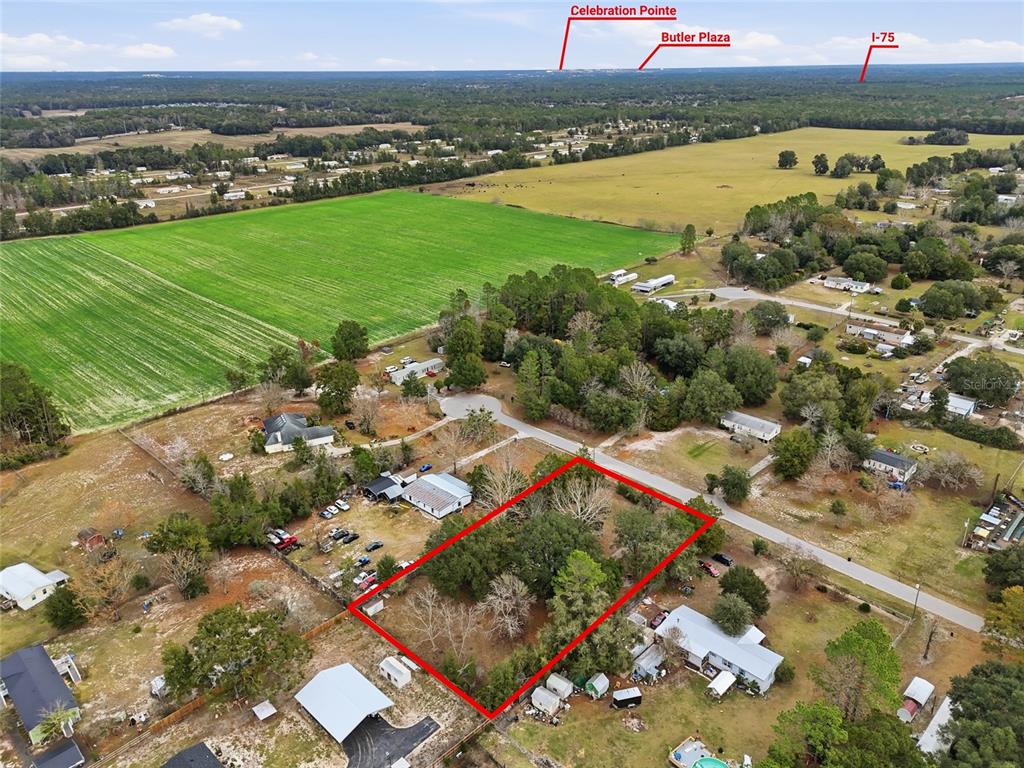An aerial view shows a rectangular plot of land outlined in red near rural housing — 9024 SW 104TH TERRACE, GAINESVILLE, FL