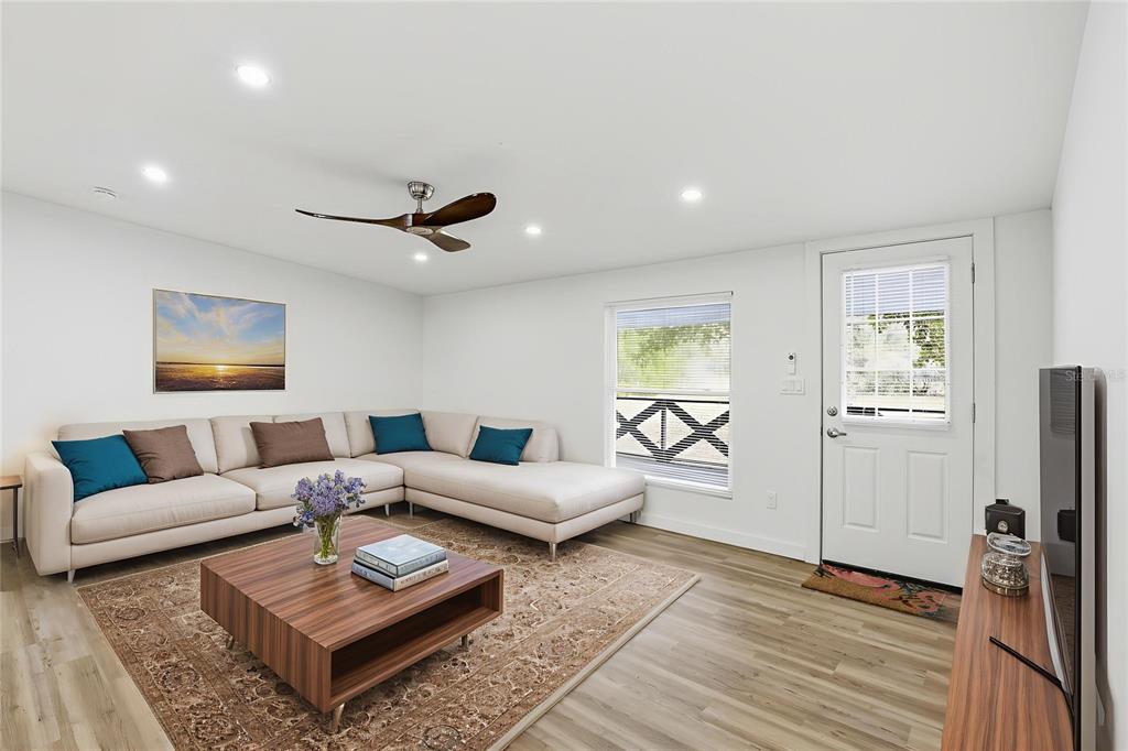 A living room features a beige sectional sofa, a wooden coffee table, and light flooring — 9024 SW 104TH TERRACE, GAINESVILLE, FL