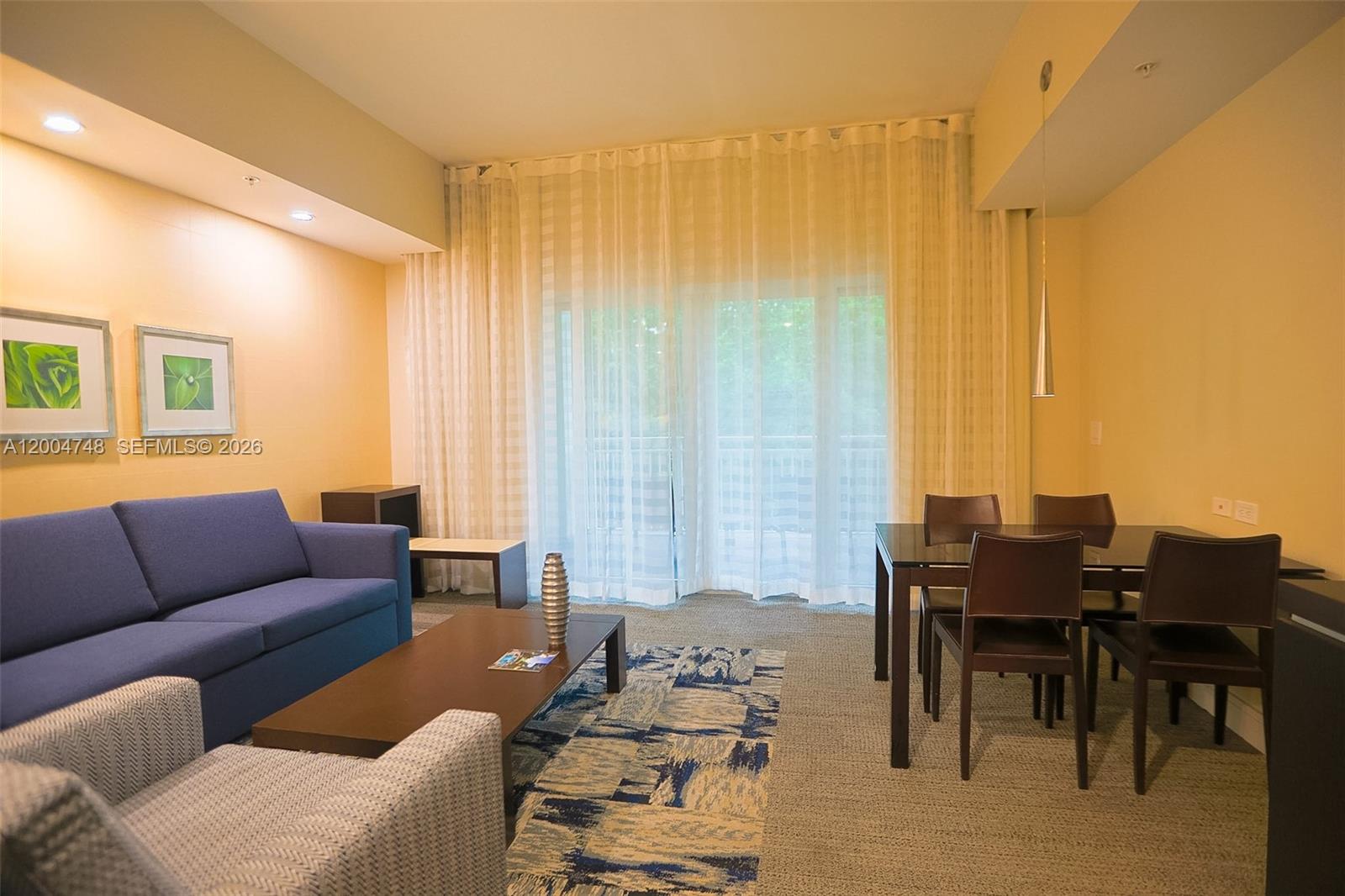 A living and dining area features a blue sofa, a coffee table, and dining furniture — 5300 NW 87th Ave # 311, Doral FL 33178, DORAL, FL