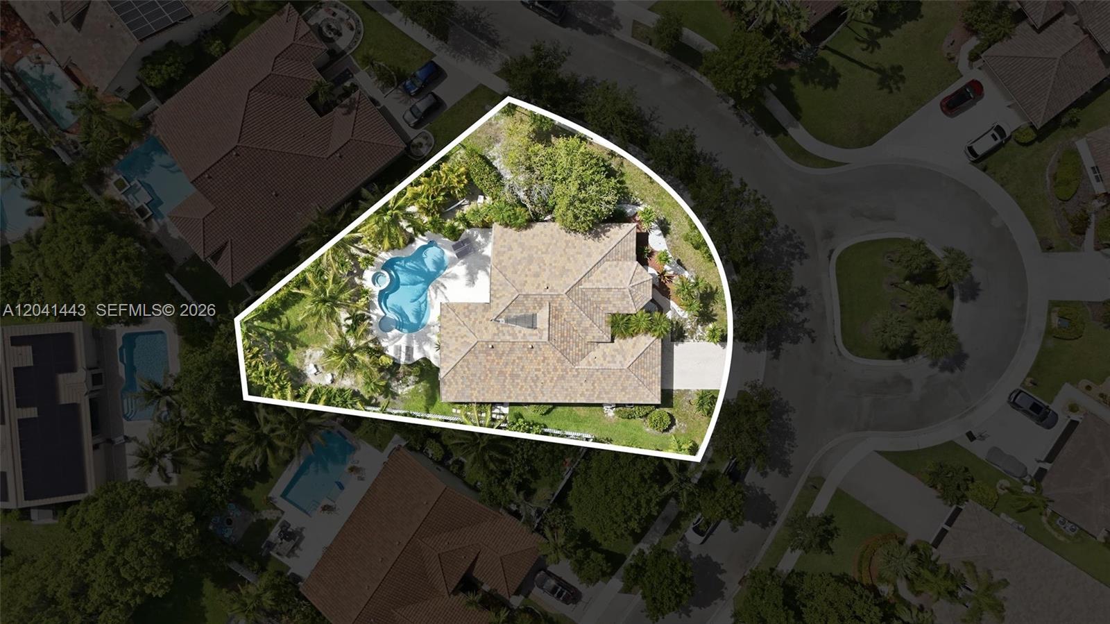 A single-story house with a paved driveway, a two-car garage, and lush tropical landscaping — 241 Fairmont Way, Weston FL 33326, WESTON, FL
