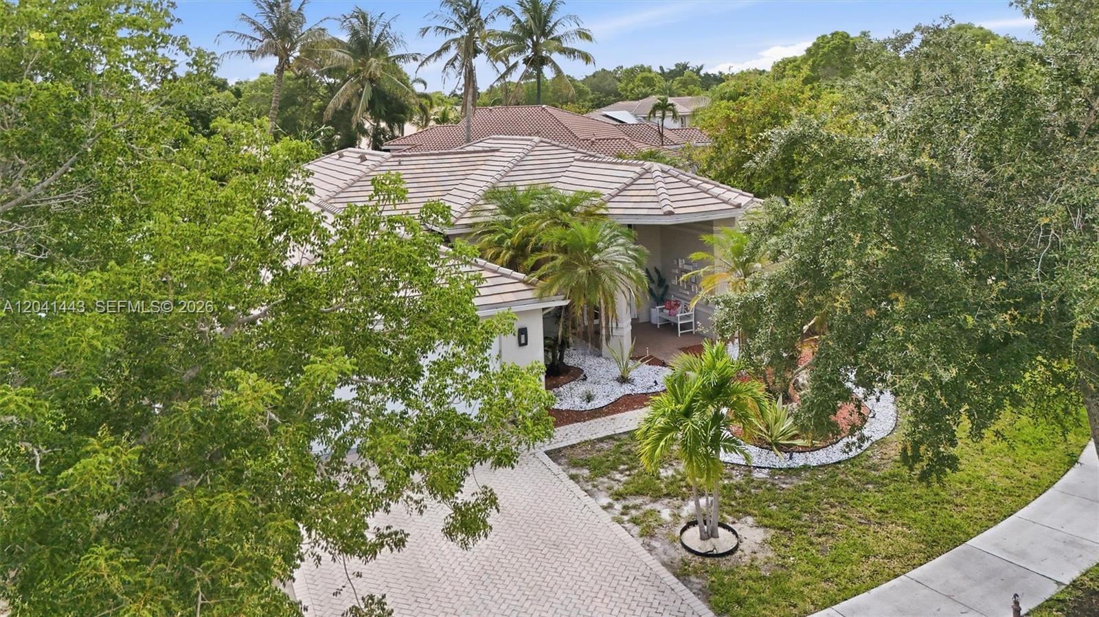 A single-story house with a tiled roof, a two-car garage, and mature landscaping — 241 Fairmont Way, Weston FL 33326, WESTON, FL