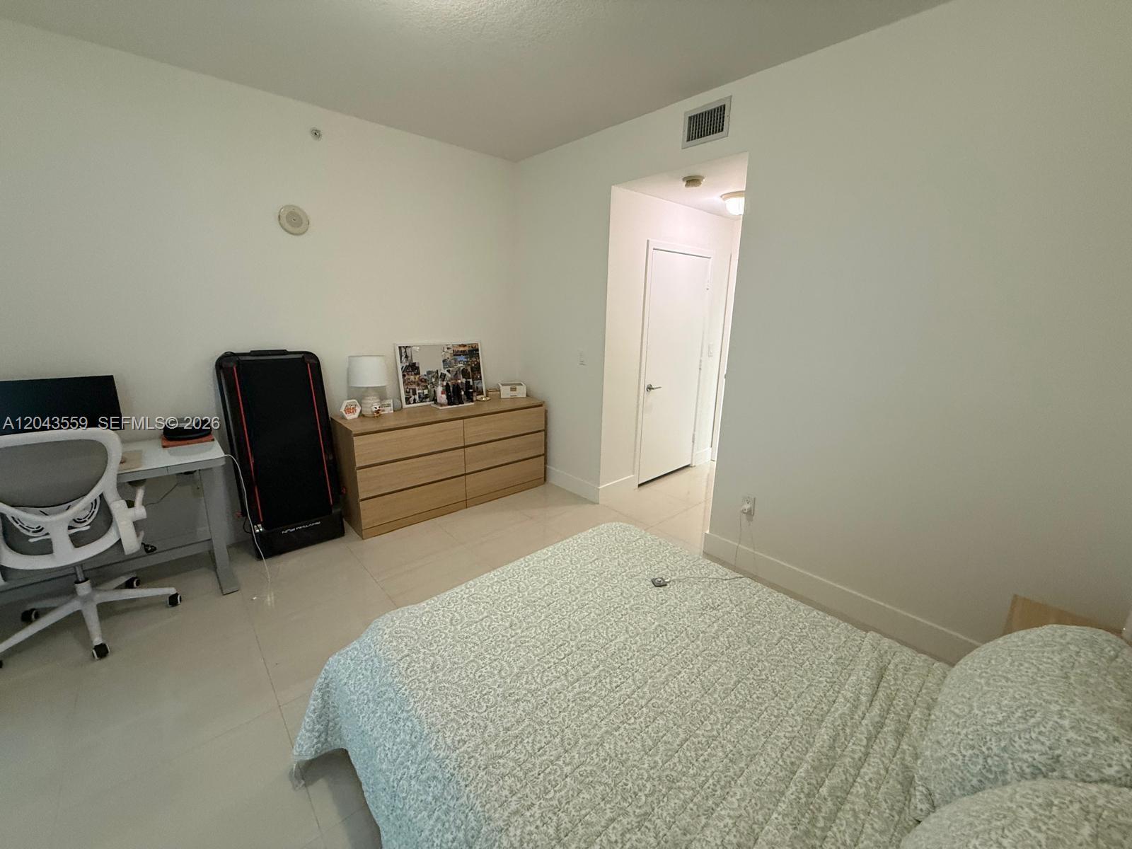 A bedroom features a bed, a desk with a chair, and a wooden dresser — 79 SW 12th St, Miami FL 33130, MIAMI, FL