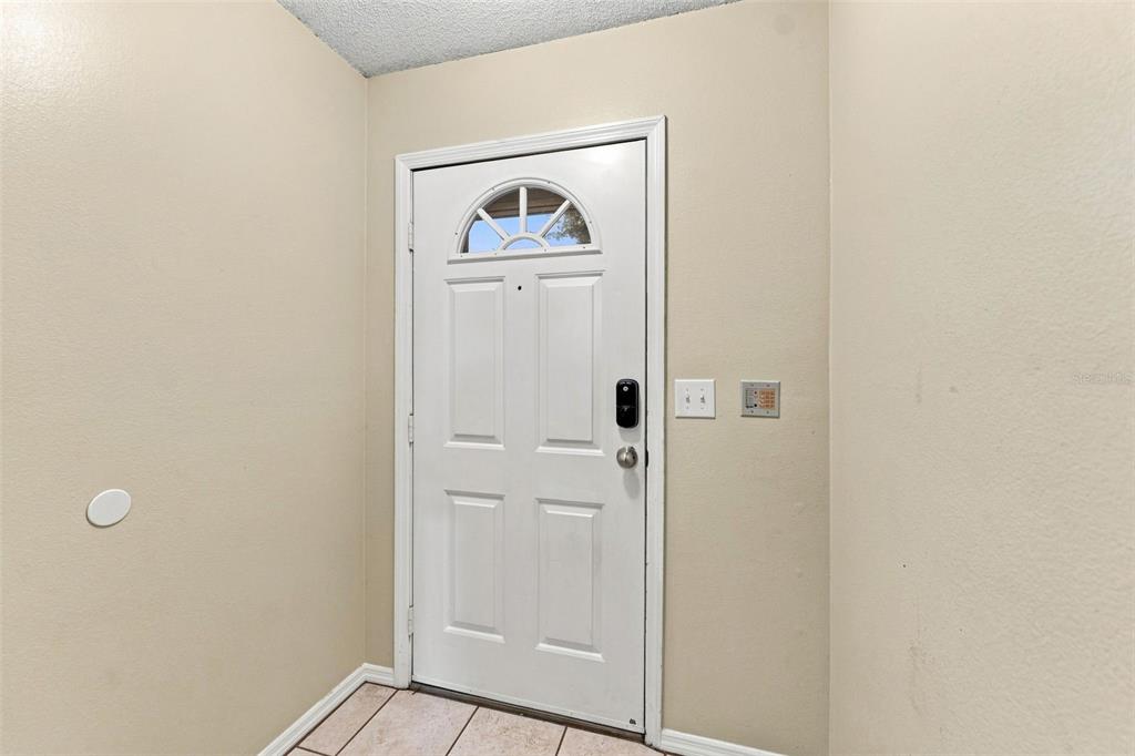 An interior entryway features a white front door with a glass arch and tile flooring — 2350 FLETCHERS POINT CIRCLE, TAMPA, FL