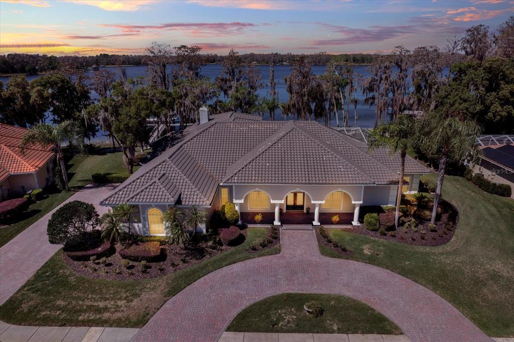 An aerial view of a single-story house with a tile roof and a circular driveway — 5643 WHITE IBIS LANE, LAND O LAKES, FL