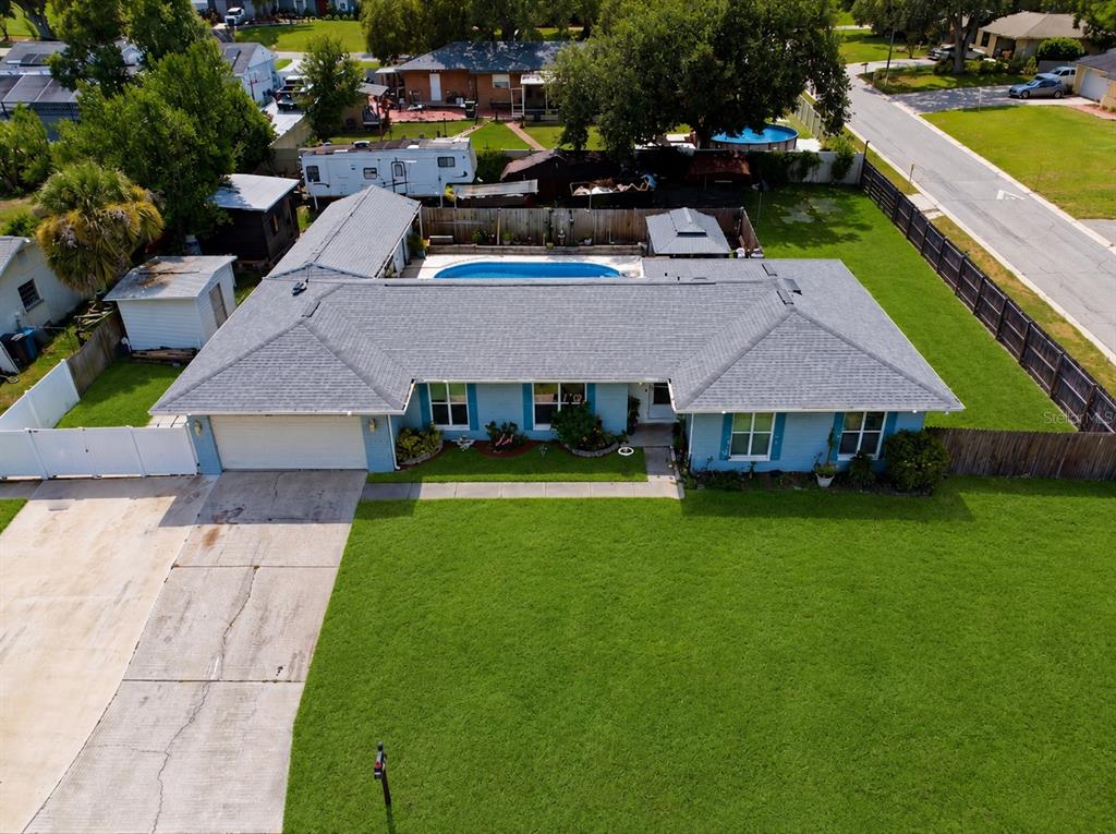 A single-story light blue brick house with a two-car garage and a front lawn — 1124 KING ARTHUR COURT, VALRICO, FL