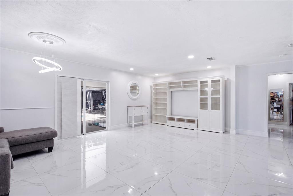 An aerial view of a single-story house with a grey roof, pool, and fenced yard — 1124 KING ARTHUR COURT, VALRICO, FL