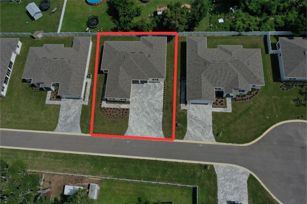 An aerial view shows a single-family home with a paved driveway and fenced backyard — 37549 TERI COURT, DADE CITY, FL