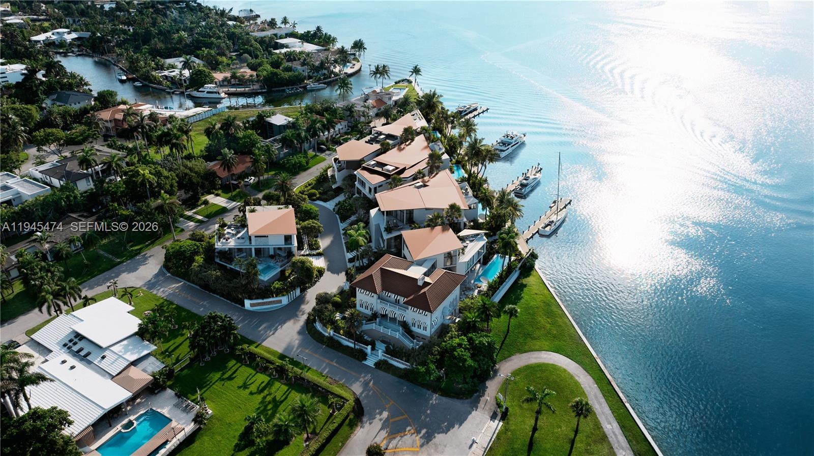 An aerial view shows luxury waterfront homes with pools and private docks along a bay — 7150 NE 72nd ST, Miami FL 33138, MIAMI, FL