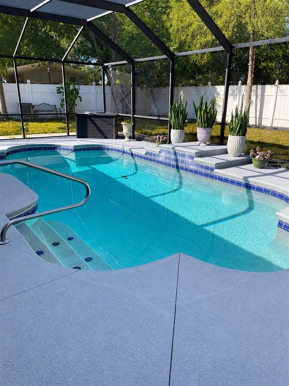 A screened-in swimming pool with a concrete deck and potted plants in a backyard — 490 WATER ROAD, OCALA, FL