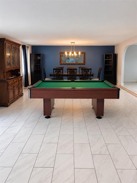 A dining room with a pool table, dark blue accent wall, and white tile flooring — 490 WATER ROAD, OCALA, FL
