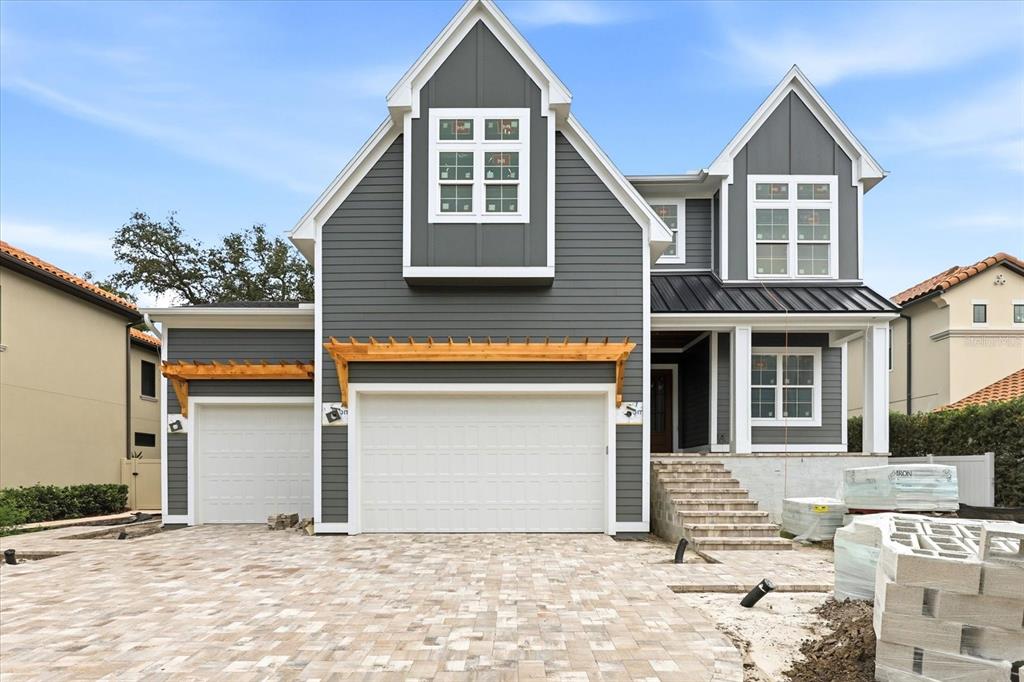 A two-story house with gray siding, a two-car garage, and a paved driveway — 4307 W SEVILLA STREET, TAMPA, FL