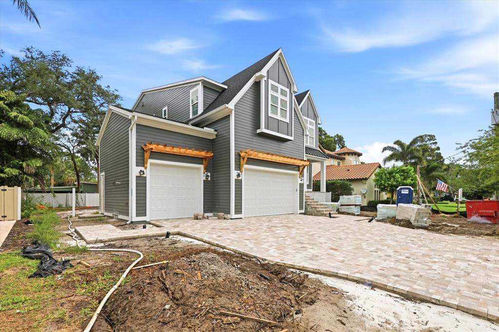 A two-story gray house with a three-car garage and a paved driveway under construction — 4307 W SEVILLA STREET, TAMPA, FL