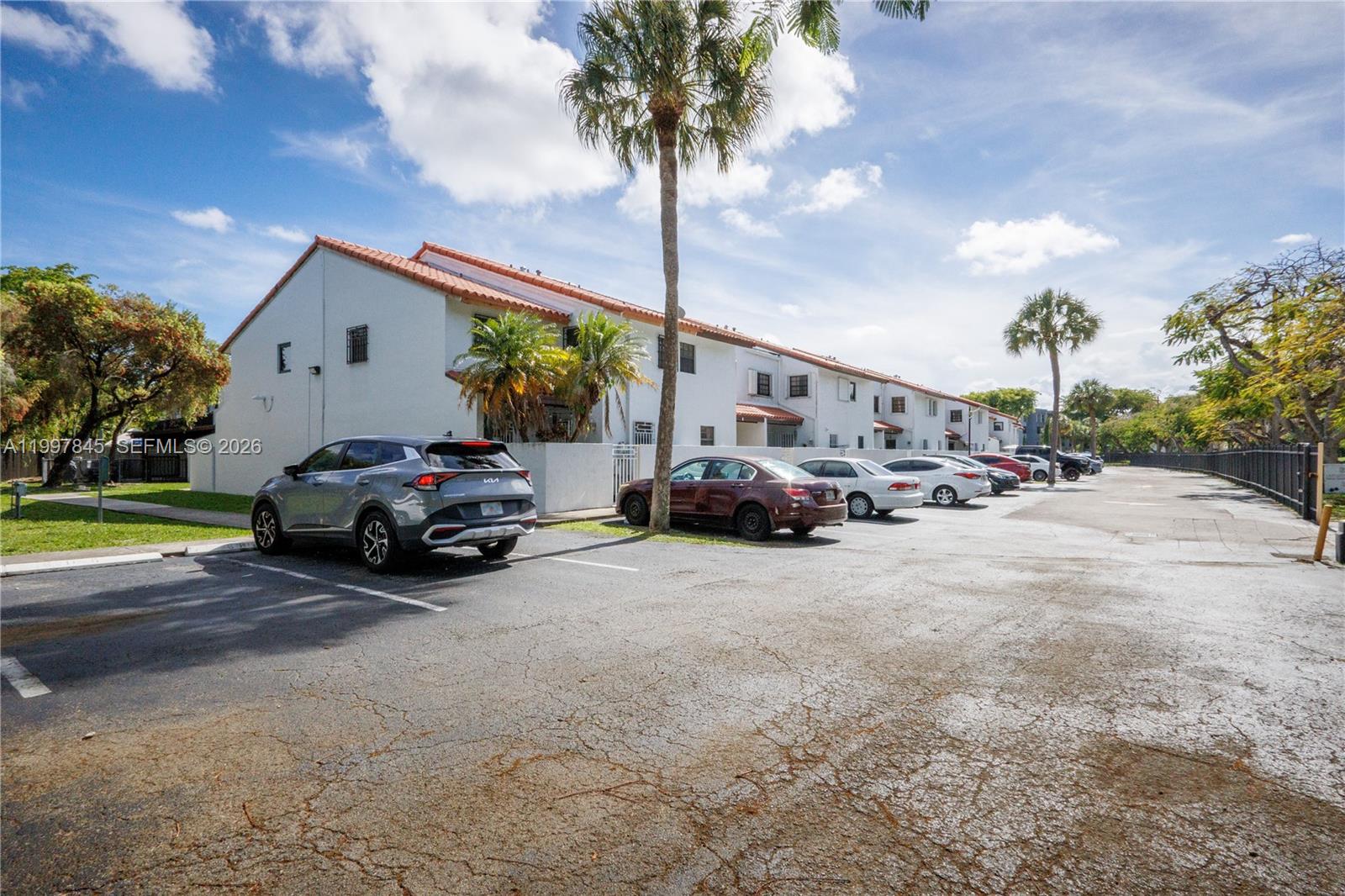 A multi-story residential building with a parking lot in the foreground — 6211 SW 138th Ct # B, Miami FL 33183, MIAMI, FL