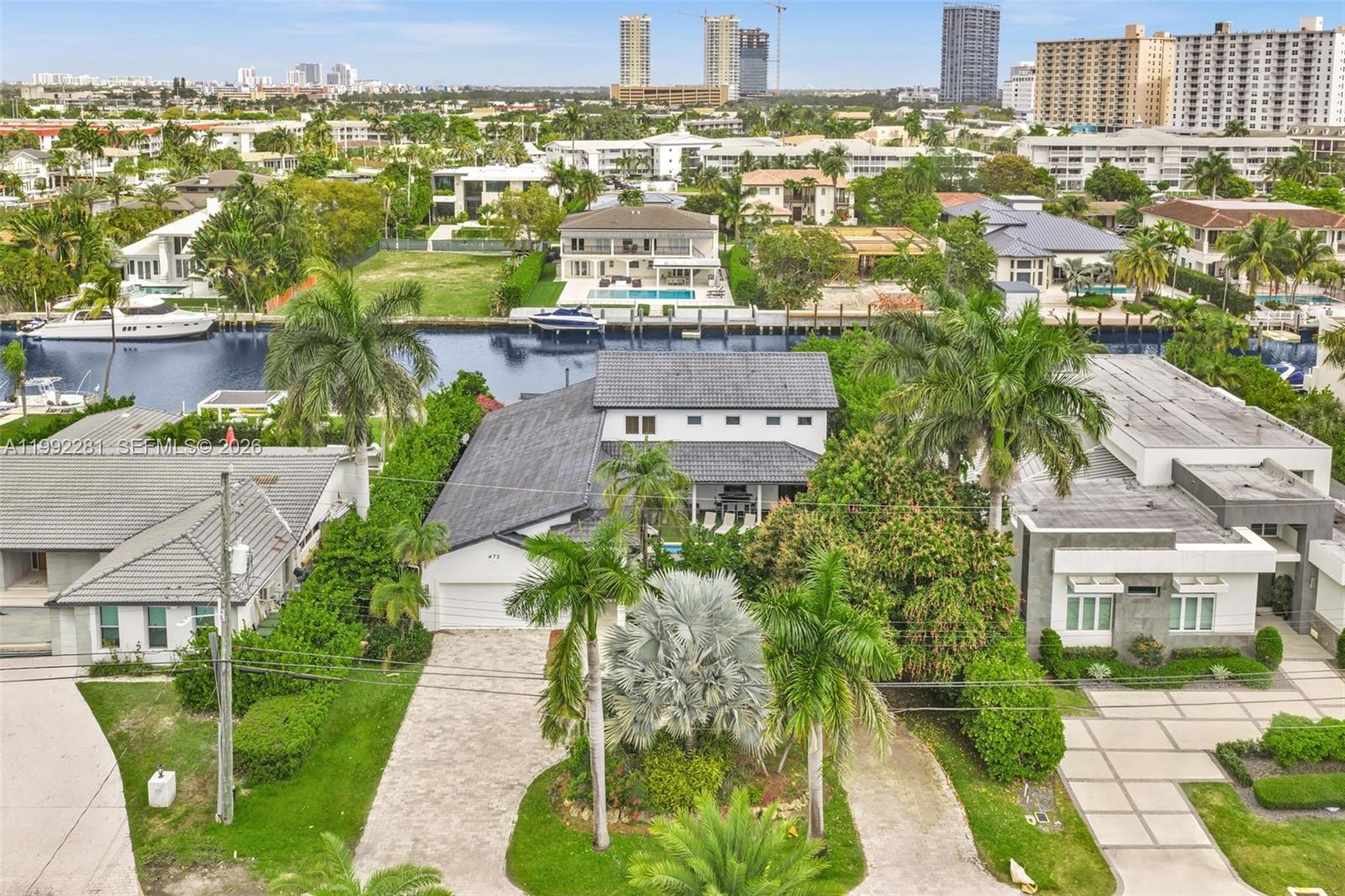 An aerial view shows a two-story house with a gray roof, pool, and canal access — 472 Sunset Dr, Hallandale Beach FL 33009, HALLANDALE BEACH, FL