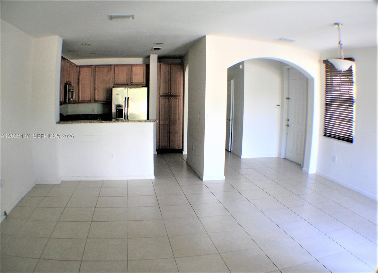 An open-concept living area features a kitchen with wood cabinets and tile flooring — 202 Las Brisas Cir, Sunrise FL 33326, SUNRISE, FL