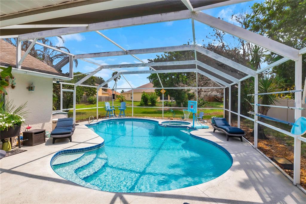 A screened-in swimming pool and spa with lounge chairs on a concrete patio — 2400 BENT PINE STREET, MELBOURNE, FL