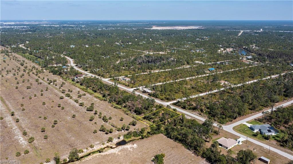 An aerial view shows a vacant, rectangular lot outlined in yellow near a paved road — 12539 GREEN GULF BOULEVARD, PUNTA GORDA, FL