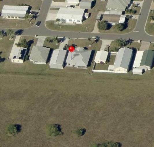This aerial view shows a residential street with several houses, including one marked by a pin — 926 SW 44th Boulevard, Okeechobee FL 34974, OKEECHOBEE, FL