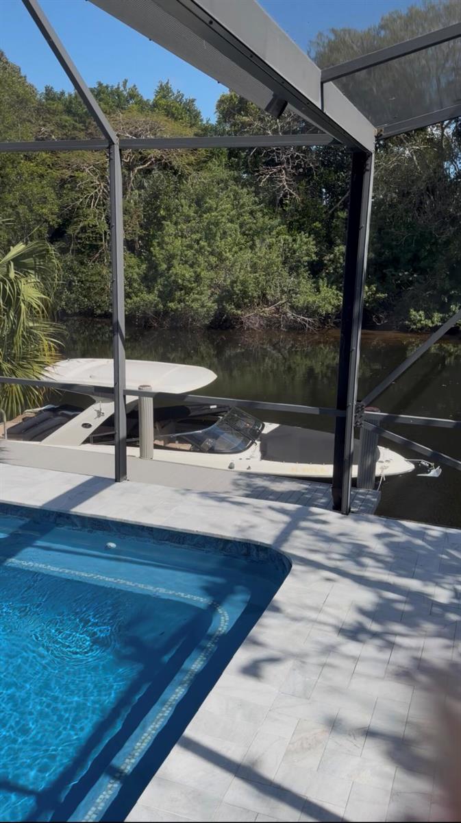 A swimming pool sits on a patio overlooking a boat docked in a canal — 550 SW 6th Avenue, Boca Raton FL 33486, BOCA RATON, FL