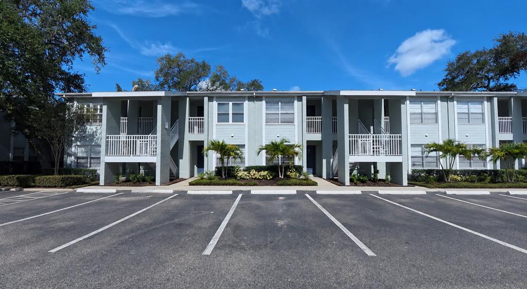 A two-story apartment building with a parking lot in the foreground under a blue sky — 5440 S MACDILL AVENUE UNIT 1I, TAMPA, FL