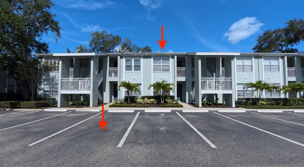 A two-story apartment building exterior features light-colored siding, white railings, and a paved parking lot — 5440 S MACDILL AVENUE UNIT 1I, TAMPA, FL