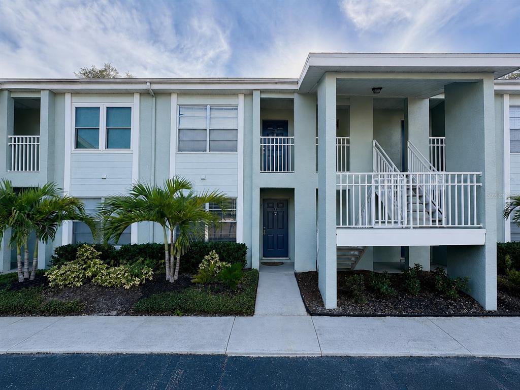 A two-story apartment building with light blue siding, white railings, and a concrete walkway — 5440 S MACDILL AVENUE UNIT 1I, TAMPA, FL