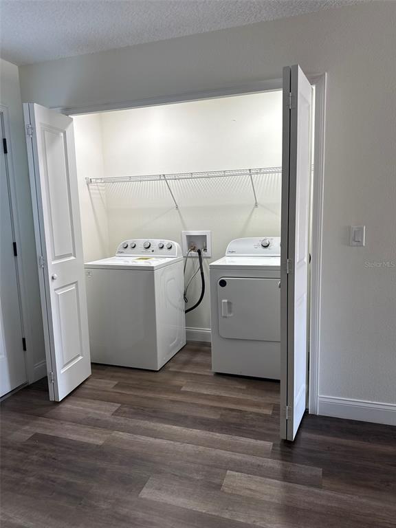 A laundry closet features a white washer and dryer set beneath a wire storage shelf — 16292 SW 30TH TERRACE UNIT 2, OCALA, FL