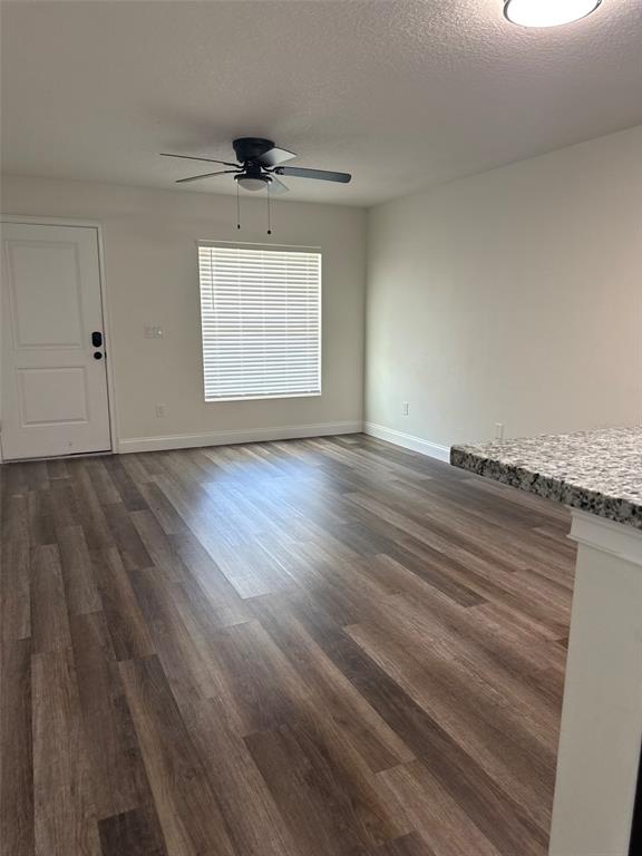 An empty living room features wood-look flooring, a ceiling fan, and a white entry door — 16292 SW 30TH TERRACE UNIT 2, OCALA, FL
