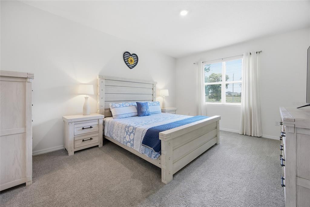 A bedroom features a light wood bed frame, matching nightstands, and blue patterned bedding — 9309 SW 60TH COURT ROAD, OCALA, FL