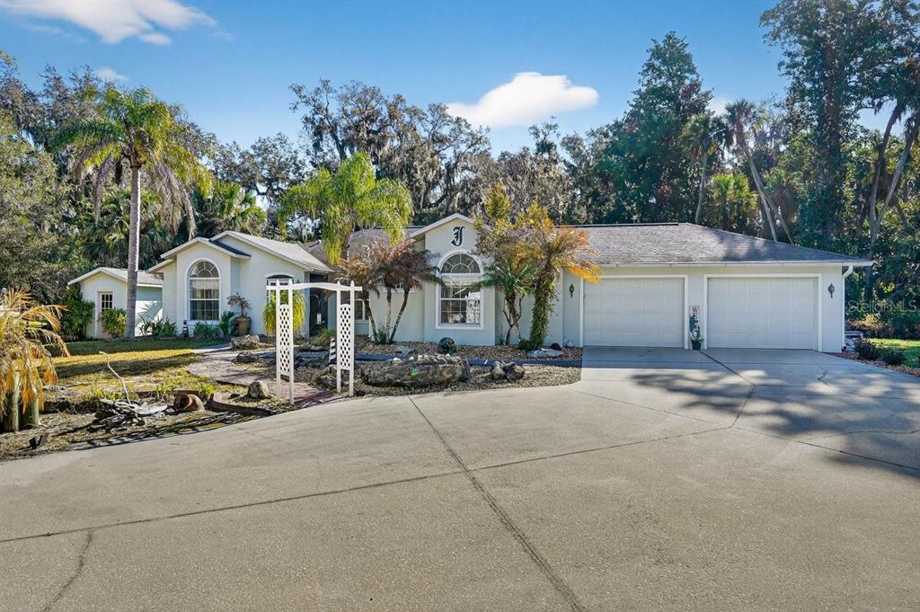 A single-story house with a large concrete driveway, a two-car garage, and a landscaped yard — 2576 SHILO GLYNN LANE, NEW SMYRNA BEACH, FL