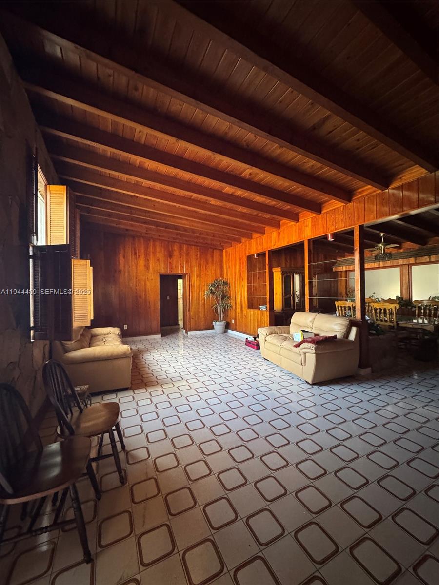 A living room features wood-paneled walls, a vaulted beamed ceiling, and light-colored tile flooring — 500 SW 39th Ct, Miami FL 33134, MIAMI, FL