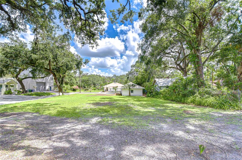 A grassy, partially shaded lot sits in front of a small white house — 00 STANLEY, TAMPA, FL