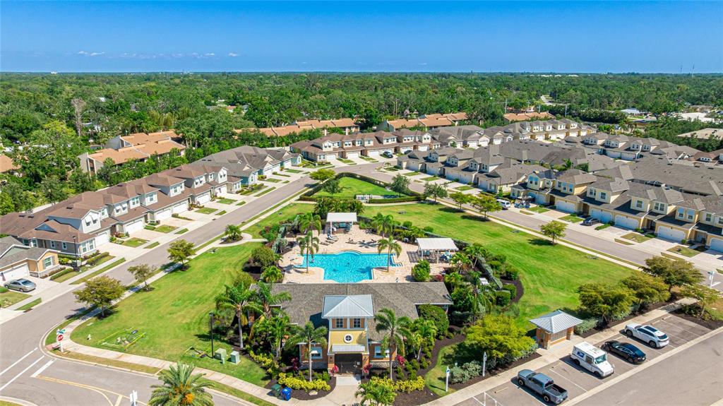 An aerial view shows a residential community with a central swimming pool and clubhouse — 3644 TIN CUP BOULEVARD, SARASOTA, FL