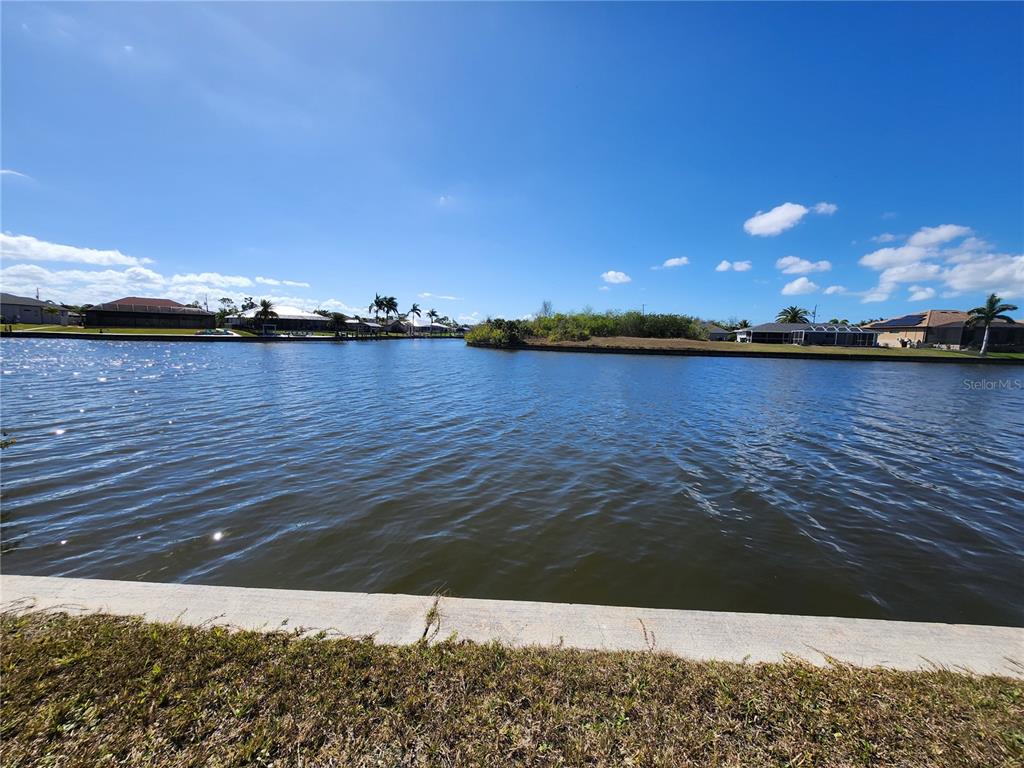 A view of a canal with houses in the background under a blue sky — 15332 ALSASK CIRCLE, PORT CHARLOTTE, FL