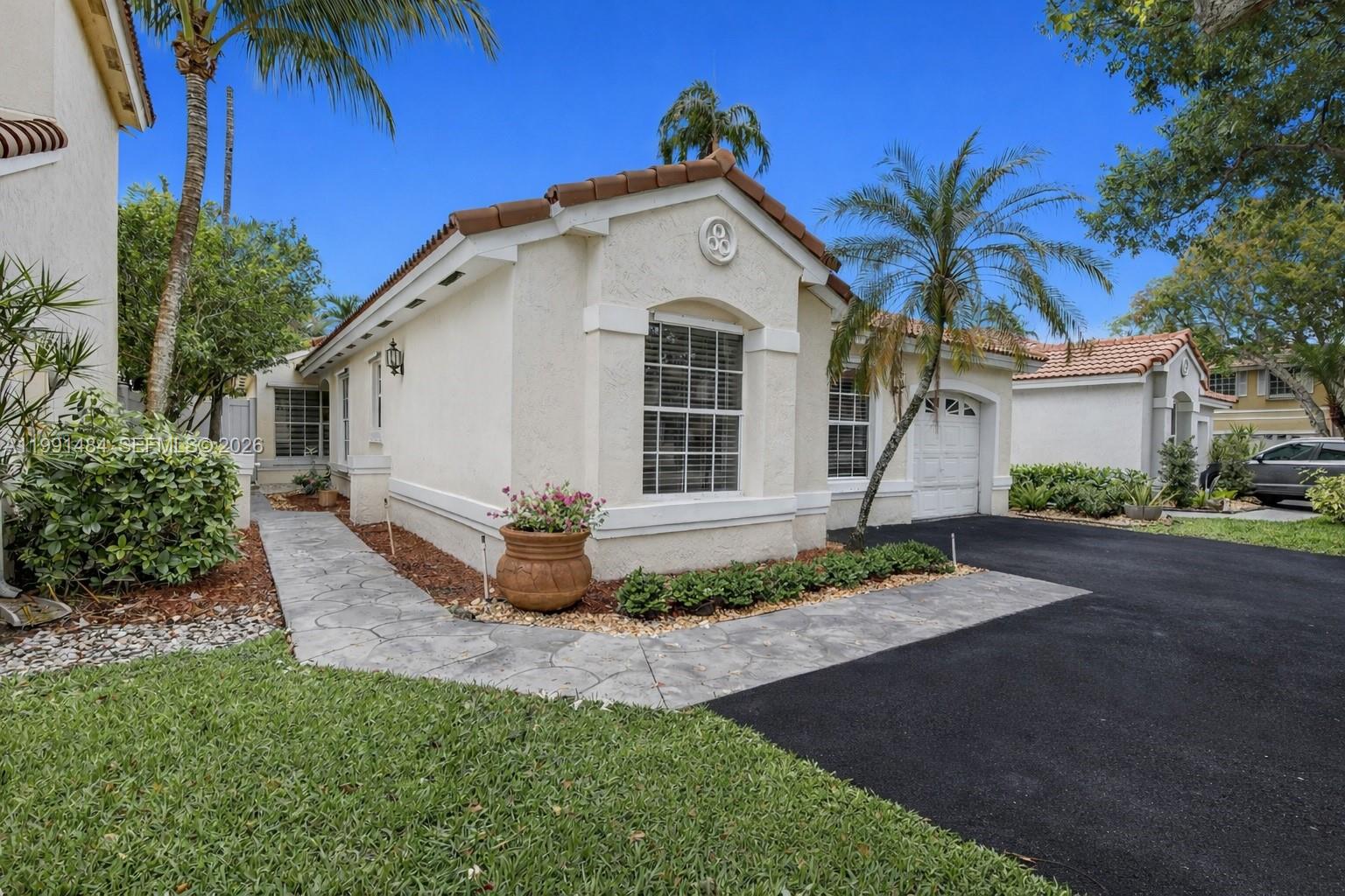 A single-story stucco house with a tile roof, a paved walkway, and a driveway — 922 Opal Ter, Weston FL 33326, WESTON, FL
