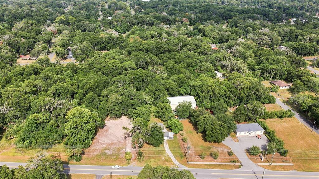 An aerial view shows a cleared lot next to a house and a paved driveway — 2107 NE 8TH ROAD, OCALA, FL