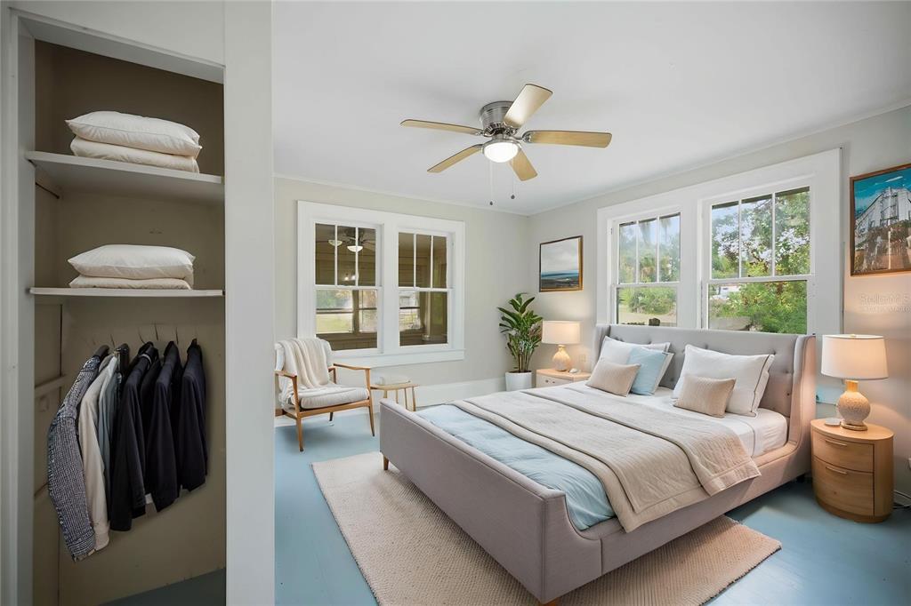 A bedroom features a gray upholstered bed, light blue floors, and an open closet — 2107 NE 8TH ROAD, OCALA, FL