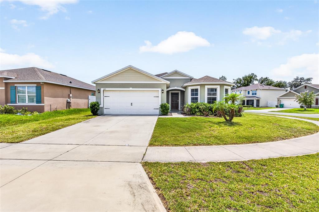 A single-story suburban house with a two-car garage and a concrete driveway — 1097 AUGUST SKY DRIVE, DELTONA, FL