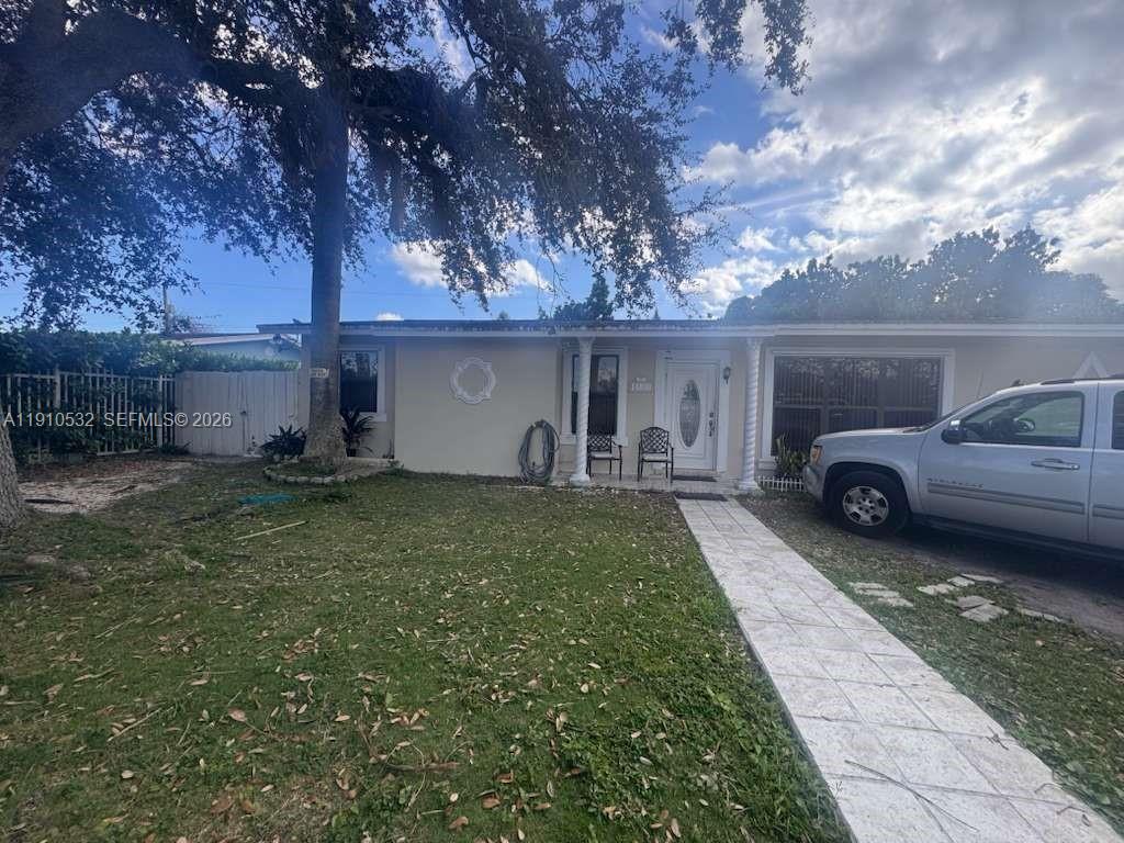 A single-story house with a light-colored exterior, a paved walkway, and a parked silver truck — 14800 SW 296th St, Homestead FL 33033, HOMESTEAD, FL