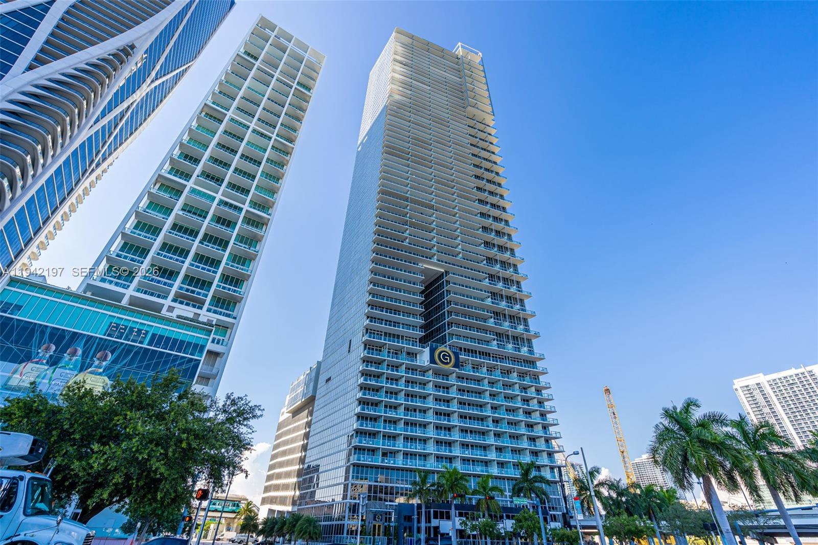A low-angle view of two modern glass skyscrapers under a clear blue sky — 1100 Biscayne Blvd # 2907, Miami FL 33132, MIAMI, FL