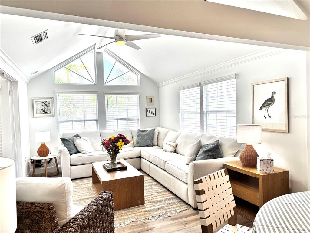 A living room features a white sectional sofa, vaulted ceilings, and a wooden coffee table — 701 BROADWAY STREET, LONGBOAT KEY, FL