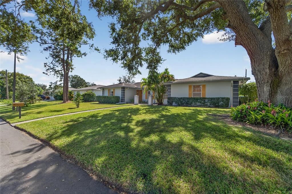 A single-story house with a large oak tree in the front yard — 1909 KIMBALL COURT S, LAKELAND, FL