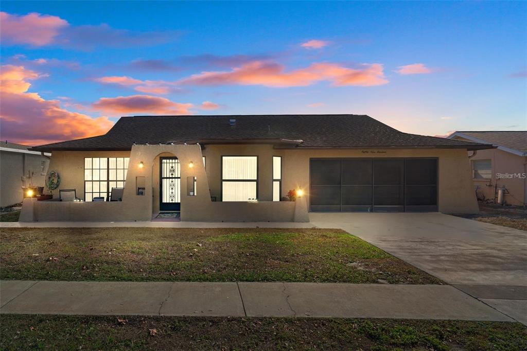 A single-story house with a stucco exterior, a front courtyard, and a two-car garage — 8914 SCHRADER BOULEVARD, PORT RICHEY, FL